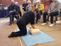 Woman demonstrating CPR on a dummy